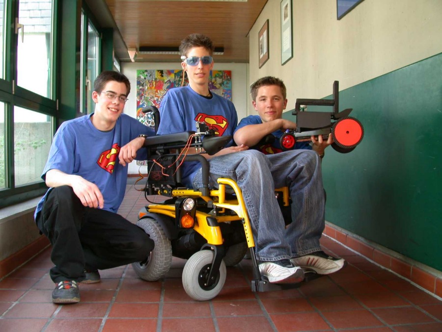 Daniel Merget, Florian Merget und Robin Stein mit ihrem umgbauten Rollstuhl im St. Michael-Gymnasium