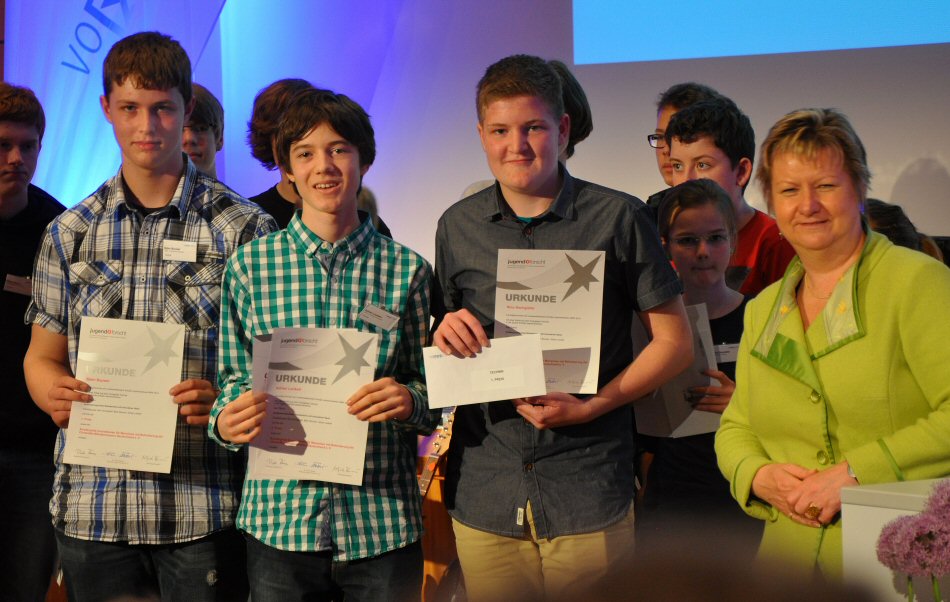 State champions Björn, Adrian and Nico receive their certificate from the Minister for Schools NRW Sylvia Löhrmann